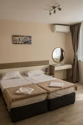 a bedroom with a large bed and a mirror at Margis Home in Burgas City
