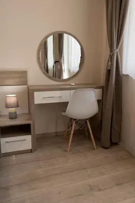 a desk with a white chair and a mirror at Margis Home in Burgas City