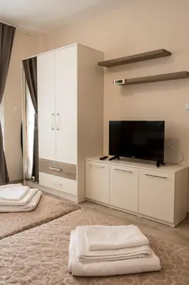 a bedroom with two beds and a flat screen tv at Margis Home in Burgas City