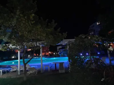 a swimming pool at night with blue lights at Apartment in Sunny beach, Complex Sun Village, 80 qm, 2 bedrooms & living room near to the beach, SWIMMING POOL, garden in Sunny Beach
