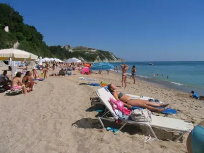 a group of people sitting on a beach at Sun Village Villa 13 in Byala