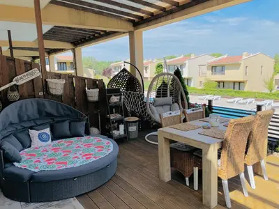 a patio with a couch and a table and chairs at Arapya Beach Apartment in Tsarevo