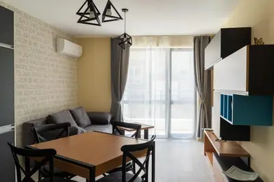 a living room with a table and a couch at La Familia Apartments in Varna City