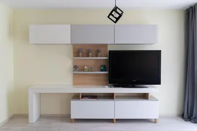 a white entertainment center with a television on it at La Familia Apartments in Varna City