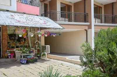 a flower shop with an umbrella in front of a building at RELAX CENTER Burgas & Free PARKING in Burgas City