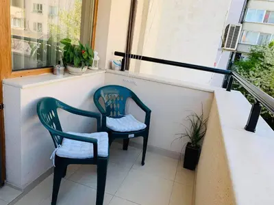 two chairs sitting on a balcony next to a window at RELAX CENTER Burgas & Free PARKING in Burgas City
