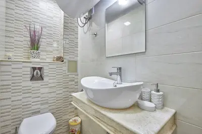 a white bathroom with a sink and a toilet at ROMANCE APARTAMENT & Free Parking in Burgas City