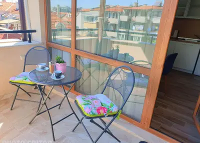 a small table and two chairs on a balcony at ROMANCE APARTAMENT & Free Parking in Burgas City