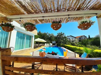 a patio with a table and a swimming pool at Milennia Family Hotel in Sunny Beach