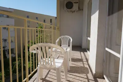 two white chairs sitting on the balcony of a building at 2 Zimmer Wohnung in Sunny Beach