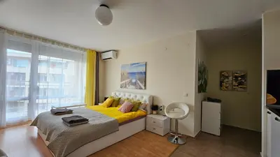 a bedroom with a bed with yellow sheets and a window at 2 Zimmer Wohnung in Sunny Beach