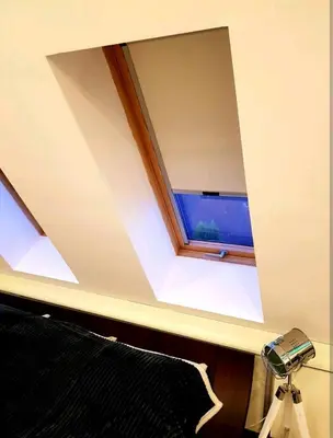 a window in the ceiling of a room with a bed at Синьо лято in Burgas City