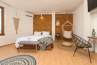 a bedroom with a bed and a chair in it at The Monkee Studios in Sveti Vlas