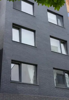 a black brick building with six windows at Stylish Retreat High-end Flat Varna Downtown by Flat Mаnager in Varna City