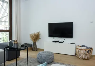 a living room with a flat screen tv on a white cabinet at Stylish Retreat High-end Flat Varna Downtown by Flat Mаnager in Varna City