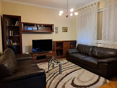 a living room with a leather couch and a television at Sunny Cozy Flat in the Centre, close to beach, 4 rooms, 105sqm in Varna City