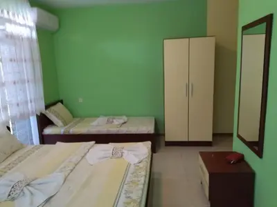 a room with two beds and a cabinet at Фамилна къща Джоко in Kiten