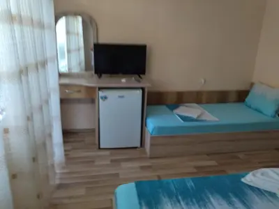 a small room with a bed and a television at Фамилна къща Джоко in Kiten