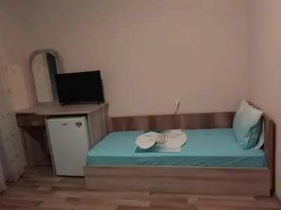 a small bedroom with a bed with two hats on it at Фамилна къща Джоко in Kiten