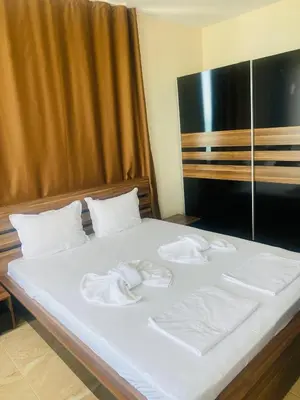a bed with white sheets and towels on it at Golden Sea View New in Pomorie