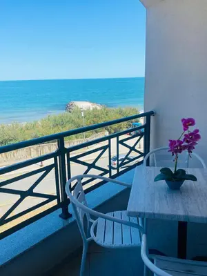 a table and chairs on a balcony with the ocean at Golden Sea View New in Pomorie