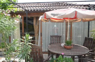 a table with an umbrella on a patio at Guest House Amazonka in Varna City