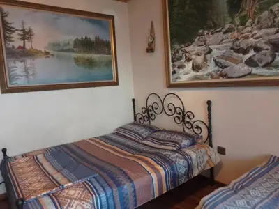 a bedroom with a bed and a painting on the wall at Guest House Amazonka in Varna City