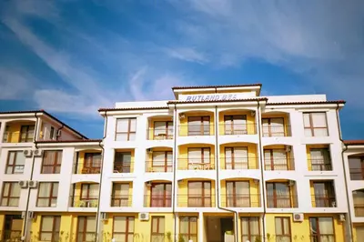 a white building with a sign on top of it at Apartment Rutland Beach in Ravda