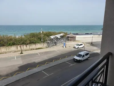 a white car parked in a parking lot next to the ocean at Таня 8 in Pomorie