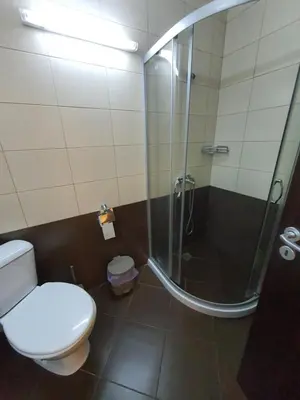 a bathroom with a toilet and a glass shower at Таня 8 in Pomorie