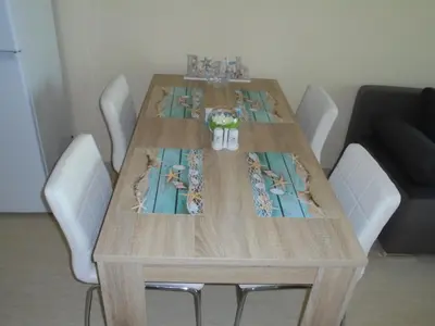 a wooden table with white chairs around it at Таня 8 in Pomorie
