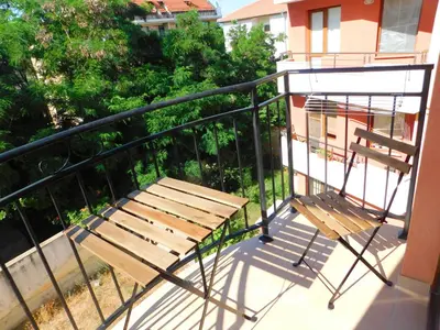 a wooden bench sitting on top of a balcony at HomeLine Kazakovi in Nesebar