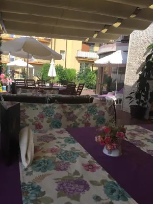 a patio with chairs and a table with flowers on it at Vila Vista Вила Виста in Sveti Vlas