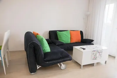 a black couch with colorful pillows in a living room at Lux Sozopoli Hills Apartments A19 и Studio А13 in Sozopol