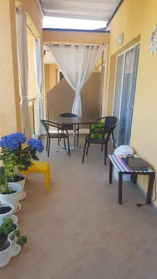 a living room with a table and chairs and flowers at Lux Sozopoli Hills Apartments A19 и Studio А13 in Sozopol