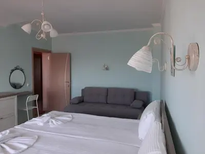 a bedroom with a bed with a couch in the background at La MER 2 in Tsarevo