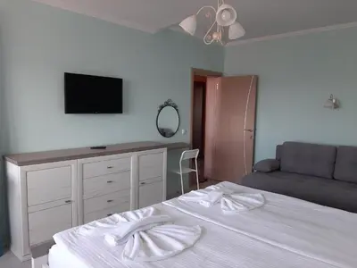 a bedroom with a bed and a flat screen tv at La MER 2 in Tsarevo
