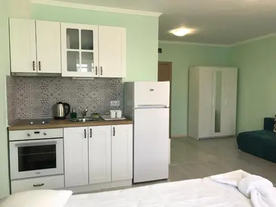 a kitchen with white cabinets and a white refrigerator at La MER 2 in Tsarevo