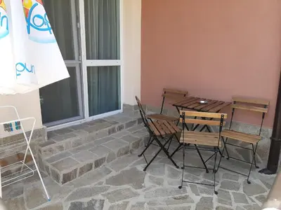 a patio with a table and chairs next to a window at La MER 2 in Tsarevo