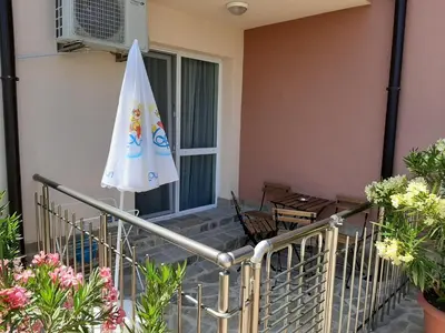 a patio with an umbrella and a table and chairs at La MER 2 in Tsarevo