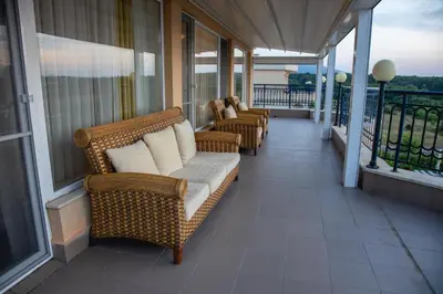a porch with wicker chairs on a balcony at Sunset Vibes in Arapya - Breathtaking Views and Pool - by Flаt Manаger in Arapya