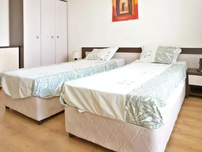 two beds sitting next to each other in a bedroom at Comfortable apartment in Slantchev Briag 65 m² Shared pool in Sunny Beach