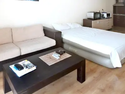 a room with a bed and a table with a couch at Comfortable apartment in Slantchev Briag 65 m² Shared pool in Sunny Beach