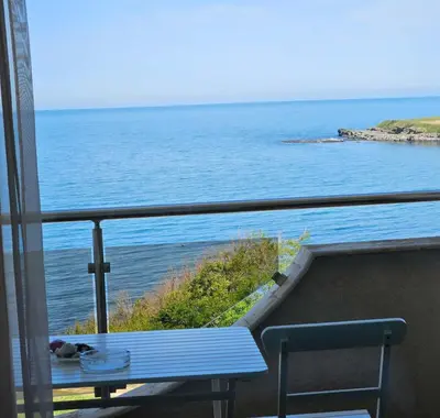 a blue bench on a balcony looking out at the ocean at INESA in Tsarevo