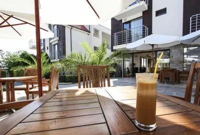 a drink sitting on a wooden table on a patio at Charming 1 Bedroom Apartment for up to 4 Guests in Sunny Beach
