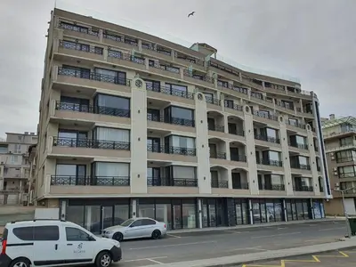 a large building with cars parked in front of it at Таня 11 in Pomorie