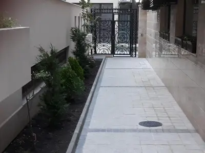 a walkway with a black gate in front of a building at Таня 11 in Pomorie