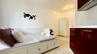 a bedroom with a white bed and a dresser at APARTELLO Modern Apartments in DownPARK in Sunny Beach
