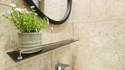 a bathroom with a mirror and a vase with flowers at APARTELLO Modern Apartments in DownPARK in Sunny Beach