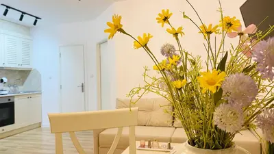a vase of flowers sitting on a table in a living room at APARTELLO Modern Apartments in DownPARK in Sunny Beach